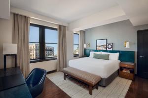 波特兰普莱斯酒店 - 傲途格精选酒店的酒店客房设有一张床、一张书桌和窗户。