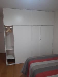 利马Piso 21 - Habitaciones en departamento - compartido的白色卧室配有床和白色橱柜