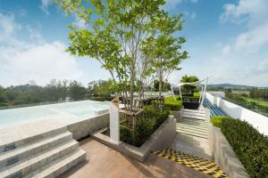 普吉镇Laguna BangTao Beach skypark Apartment的屋顶上树的游泳池