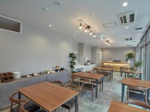 泉佐野EZ HOTEL 関西空港 Seaside的餐厅设有木桌、椅子和柜台