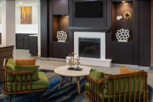 格尔夫波特海湾港比洛克西费尔菲尔德套房酒店的客厅配有两把椅子和壁炉