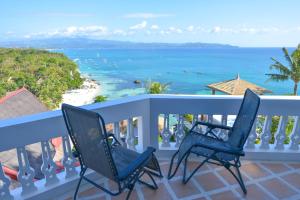 长滩岛Tropicana Ocean Villas的两把椅子坐在一个俯瞰着大海的阳台