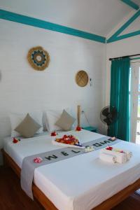 吉利特拉旺安Casa Kapuas的一间卧室配有两张鲜花床。