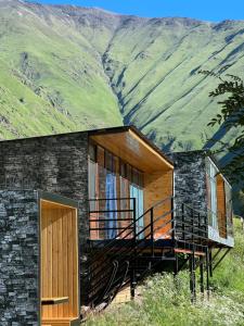 ArdotiArdoti Guest House的一座带甲板和山脉的房屋
