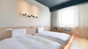 札幌Vessel Hotel Campana Susukino的一间卧室设有两张白色的床和窗户