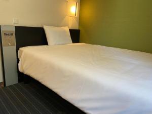 名古屋名古屋伏见桑科旅馆的一张大白色的床,位于酒店客房内