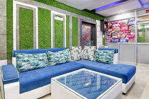 兰奇FabHotel Star Lotus的一间设有蓝色沙发和绿色墙壁的客房