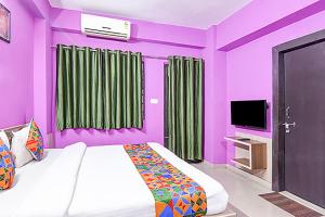兰奇FabHotel Star Lotus的一间紫色卧室,配有一张床和一台电视