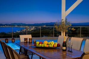 罗德岛卡利地亚Rhodes Kallithea Villa - Zafira Private Pool Gem的一张桌子,上面放着一碗水果和一瓶葡萄酒