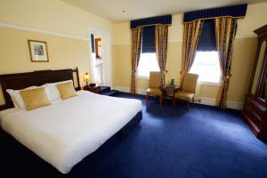 肯图巴卡林顿酒店的一间卧室设有一张大床和两个窗户。