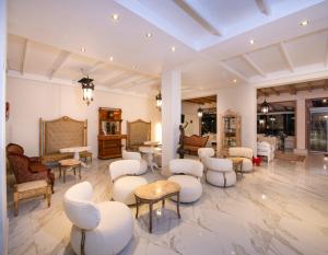 耶奥伊乌波利斯俄耳甫斯度假酒店（仅限成人）的一间设有白色椅子和桌子的等候室