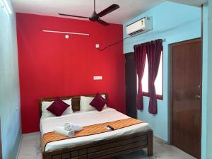 KottakupamAuro Galaxy Pondy with Swimming Pool的一间卧室配有一张红色墙壁的床