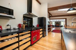 纳尔逊Korepo Lodge @ Ruby Bay的厨房配有黑色台面和红色家电
