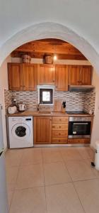 AsklipiḯonYiannis Village house的厨房配有木制橱柜和白色的电器