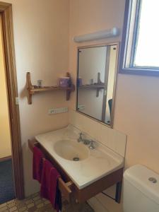 西怀厄朗True blue Motor Inn的一间带水槽、镜子和卫生间的浴室