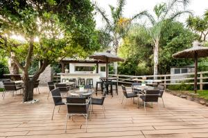 卡萨雷斯Villa Bermeja的一个带桌椅和遮阳伞的庭院