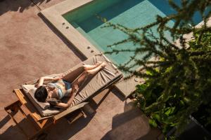 桑丹斯基Medite Spa Resort and Villas的躺在游泳池旁长凳上的女人