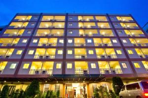 芭堤雅市中心芭提雅黄金海酒店 - SHA Extra Plus的一座带灯的大型公寓楼