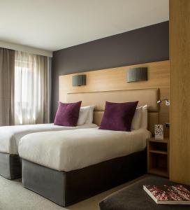 普罗旺斯艾克斯Grand Hôtel Roi René Aix en Provence Centre - MGallery的酒店客房配有两张带紫色枕头的床