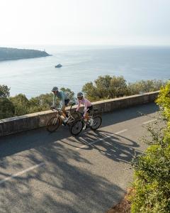博索莱伊Penthouse over Monaco的两人在靠近海洋的路上骑车