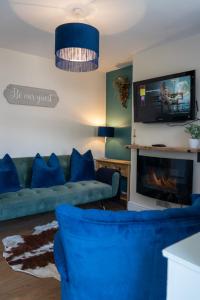 沃里克The Plumb Townhouse in Warwick Centre的客厅配有蓝色的沙发和电视
