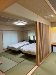 长野大志日式旅馆的一间卧室设有两张床和大镜子