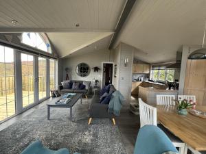达尔比蒂Holly Blue - Cosy wooden lodge Kippford的客厅配有沙发和桌子