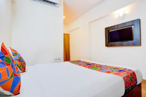 班加罗尔FabHotel GRK Comforts的一间白色卧室,配有床和电视