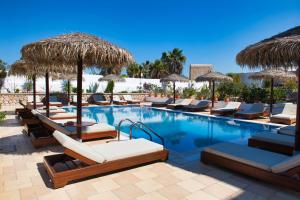 卡马利安吉拉别墅酒店的一个带躺椅和遮阳伞的游泳池