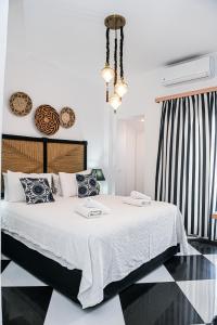 费拉Georgia Pelekanou Studios的卧室配有一张带白色床单和枕头的大床。