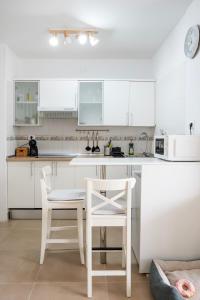 拉斯加莱塔斯Relax studio Primavera的厨房配有白色橱柜和桌椅