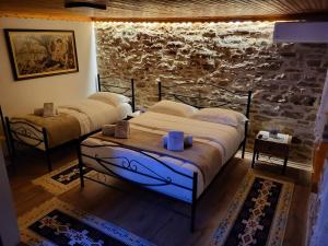 吉诺卡斯特Guest House Hasko的一间卧室设有两张床和石墙