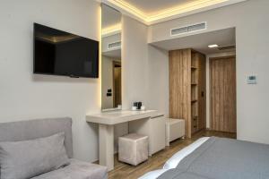 扎金索斯镇帕拉提诺酒店的一间卧室配有一张床、一张书桌和一台电视。