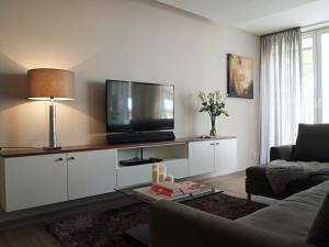 万根沃格Wohnung 10 Haus Oldenburg的客厅配有白色橱柜上的平面电视