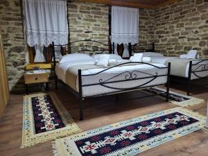 吉诺卡斯特Guest House Hasko的两张床铺,位于一间有两块地毯的房间