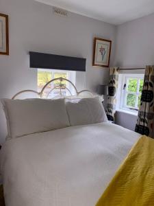韦克斯福德Rathjarney Gatelodge的一间卧室配有一张带白色床单的床和一扇窗户。