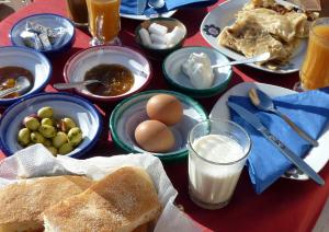 梅尔祖卡La Vallée des Dunes - Auberge, bivouacs et excursions的餐桌上放着鸡蛋和面包等食物