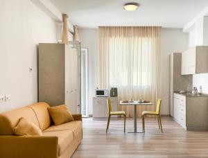 切塞纳蒂科Nido Suite & Apartments的客厅配有沙发和桌椅