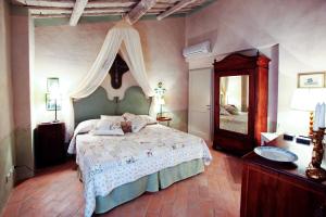 锡耶纳坡德利拉斯特雷加酒店的一间卧室配有一张大床和镜子