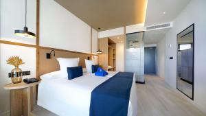 库拉海滩H10 Costa Mogán的一间卧室配有一张大白色床和蓝色毯子
