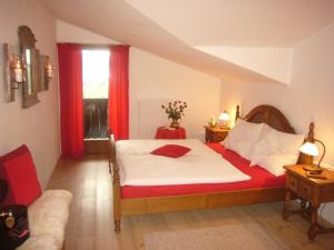 上柯尼希山麓米尔巴赫达斯索耐克公寓的一间卧室配有床和红色窗帘的窗户