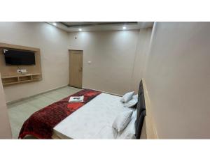 Sītāpur MūāfiThe Ramagya Hotel, Chitrakoot的配有一张床和一台平面电视的酒店客房