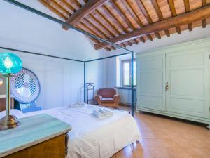 StradaApartment Casa Renai a San Gimignano-7 by Interhome的一间卧室配有一张床和一把椅子