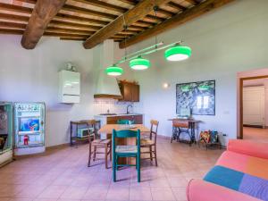 StradaApartment Casa Renai a San Gimignano-7 by Interhome的厨房以及带桌椅的起居室。