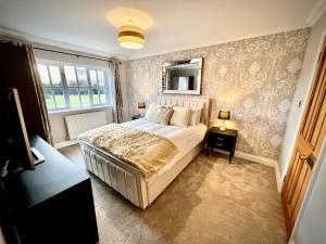 剑桥Honey Hill Cottage - 4 Bedroom Detached House的一间卧室设有一张大床和一个窗户。