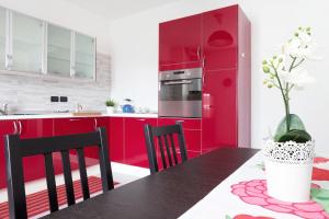 维纳利亚瑞勒A Pochi Passi的厨房配有红色橱柜和桌椅