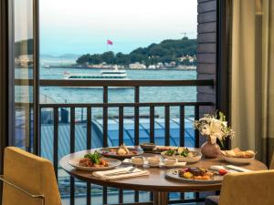 伊斯坦布尔诺富特伊斯坦布尔博斯普鲁斯酒店 的阳台上的一张桌子上放着两盘食物