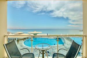 迪巴富吉拉丽笙度假酒店的设有一个游泳池的度假村阳台,享有风景