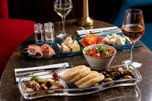 布加勒斯特布加勒斯特丽笙酒店的一张桌子,上面放着一盘食物和酒