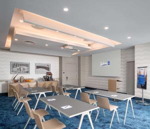 布加勒斯特布加勒斯特丽笙酒店的一间会议室,配有桌椅和白板